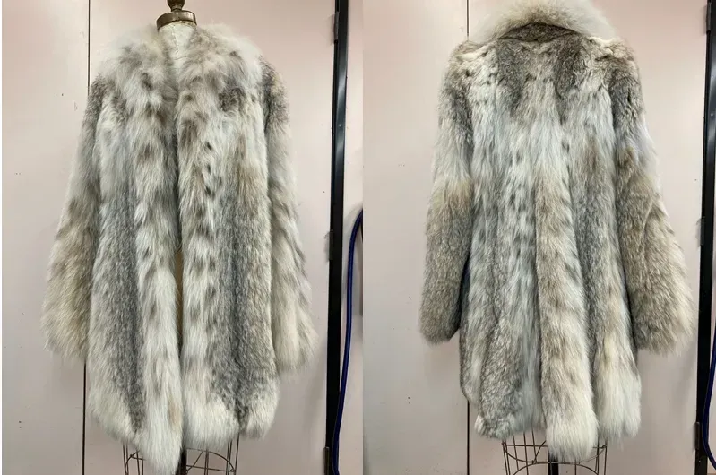 A lynx coat photographed front and back against the Edwards-Lowell workroom wall